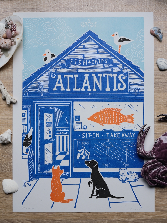 A blue, orange and black print of a fish and chip shop called Atlantis, outside there are waiting 2 dogs, a cat and some seagulls
