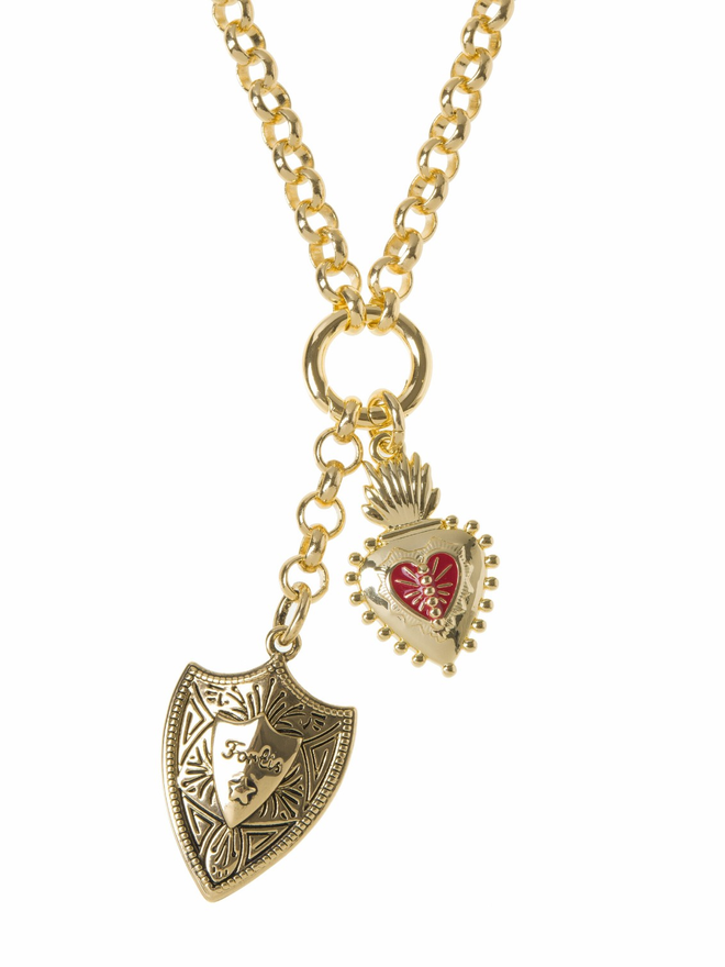 Gold shield and sacred heart charms hanging from a gold belcher chain necklace on a white background