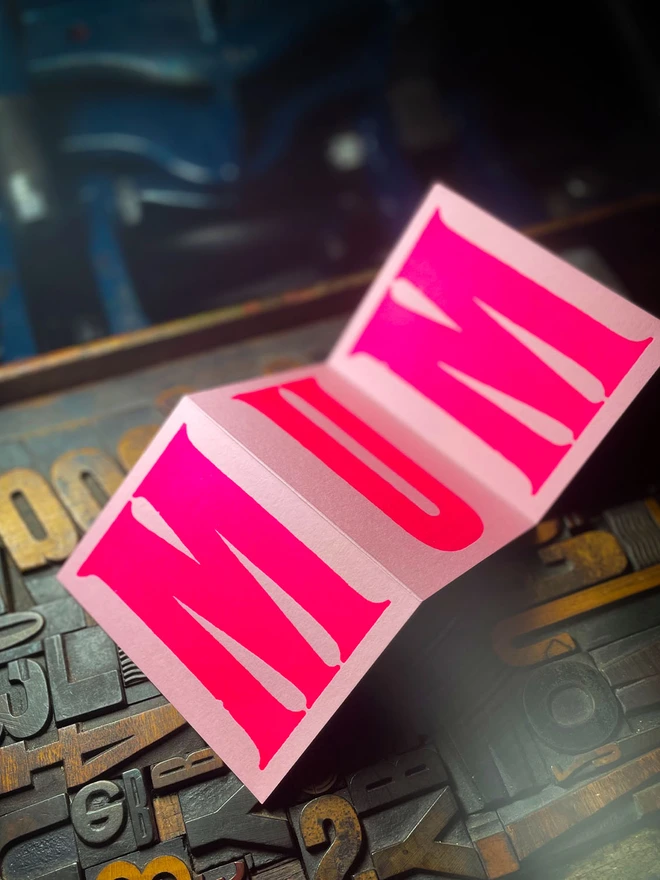 An artisan Mother’s Day concertina card printed in bold Runic Grotesque type using fluorescent pink ink on thick GF Smith Colorplan Candy Pink card, letterpress printed with a deep impression.