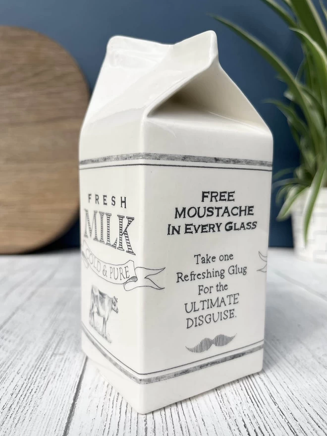 ‘Free moustache in every glass’ is humorously written on a handmade ceramic milk carton.