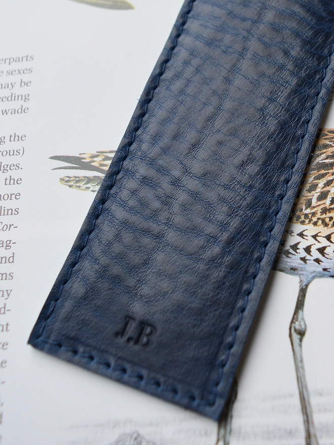 A navy blue ethically produced vegetable tanned Italian leather bookmark lined with an original silk escape map from the Cold War personalised with silver foil initials with the initials M and S and A by natthakur