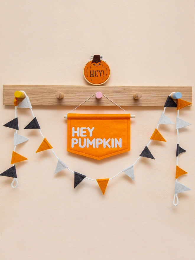 Orange felt wall banner with the words "Hey Pumpkin" written in a white glitter felt.