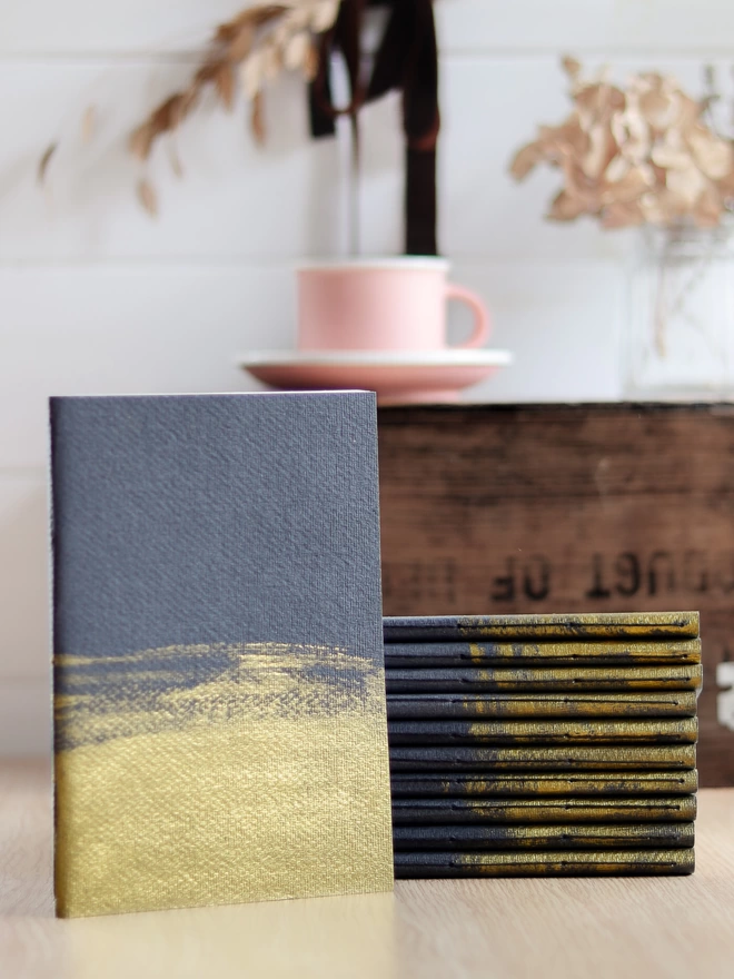 stack of black and gold notebooks