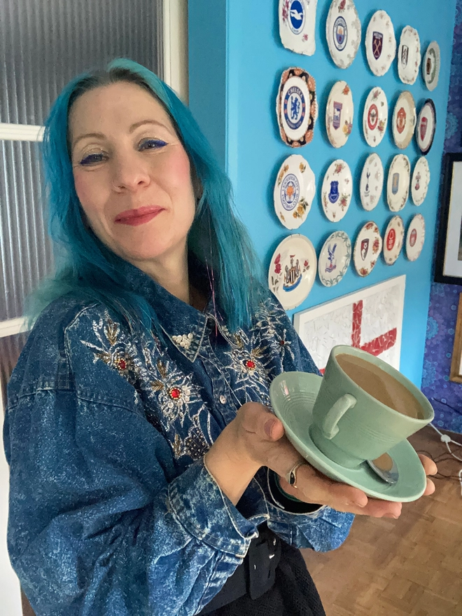 A pale green 1940s cup and saucer from the company Beryl Ware. The cup is filled to the brim with resin ‘tea’. There is a tea spoon in the saucer which has a drop of resin tea in its bowl.