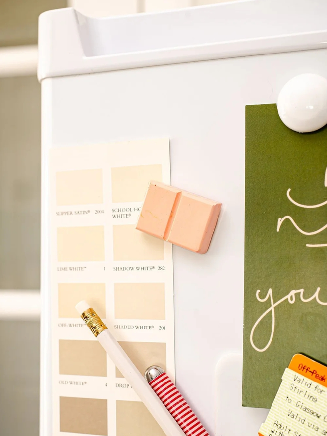 ceramic chocolate magets. a ruby chocolate magnet on a fridge door.