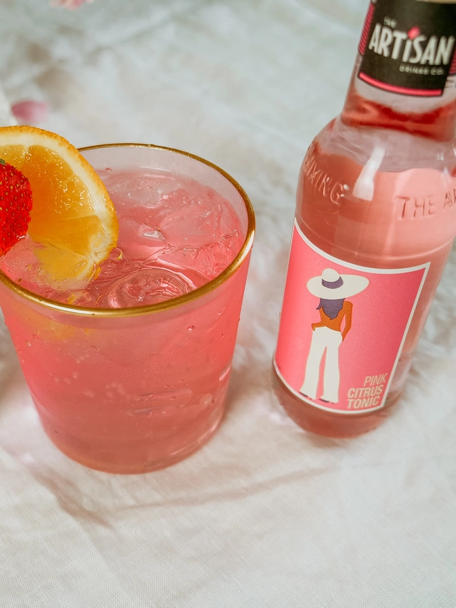 Artisan Drinks Pink Citrus Tonic next to a pink G&T