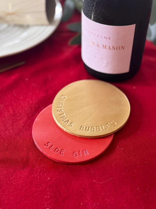 a gold and red leather coaster on a red table cloth.