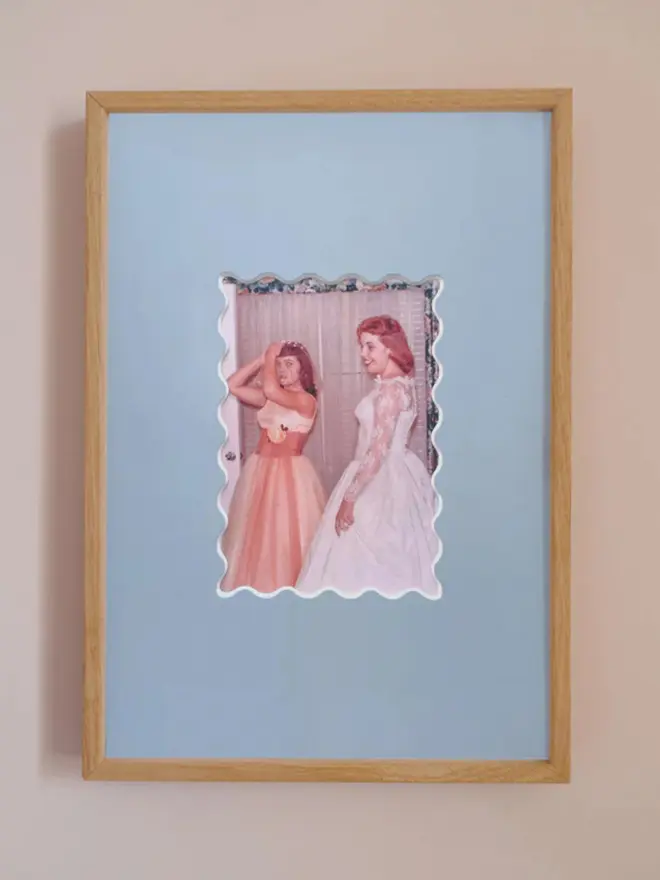 Ric rac photo mount frame with a blue mount featuring a decorative ric rac boarder around a centered Instax photo, displayed on a neutral beige wall.