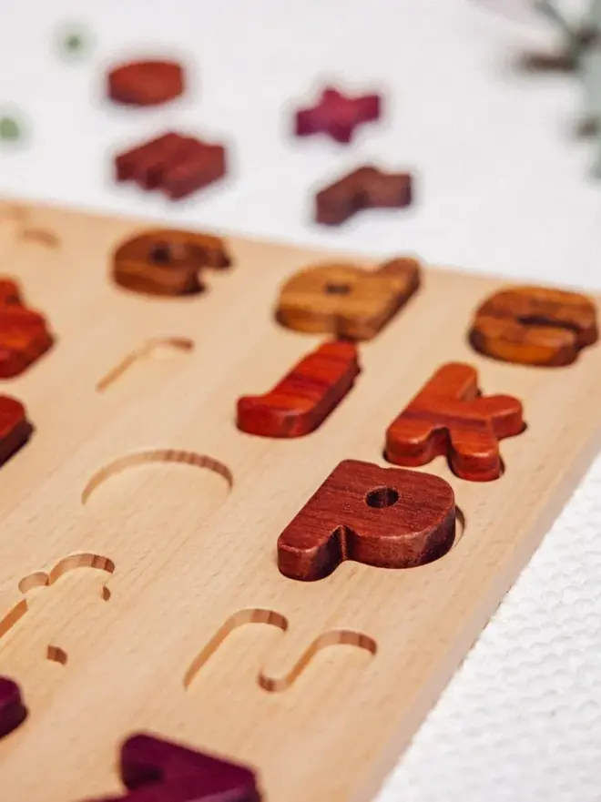 Wood Alphabet Puzzle Heirloom Toy, on a white table. 