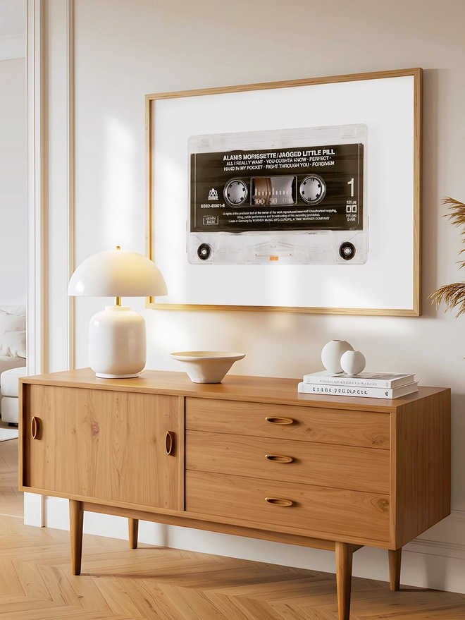 jagged little pill alanis morrisette cassette tape print. framed print on wall above wooden dresser.