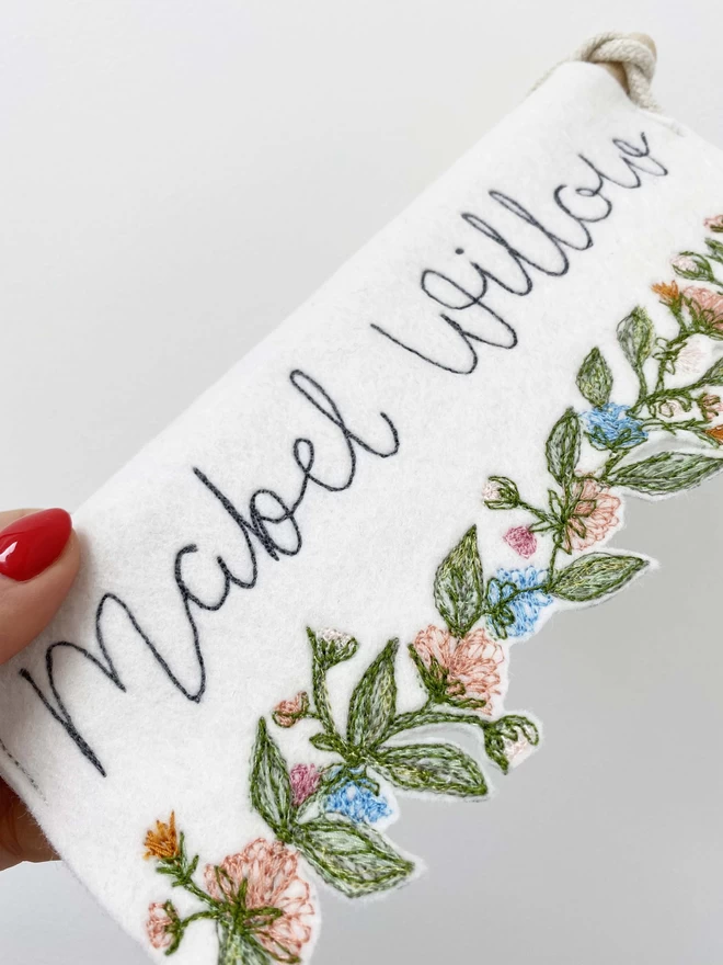 Flower Trim Personalised  Felt Banner being held with red nail varnish