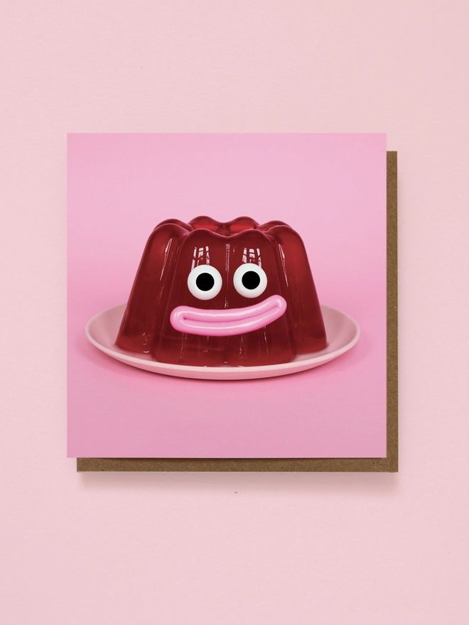 A happy red jelly on a pink plate and on a Pink Background 