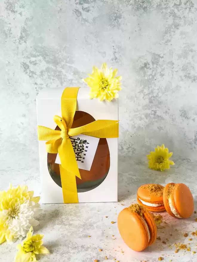 Orange Carrot easter egg with orange carrot cake macarons in a gift box with flowers