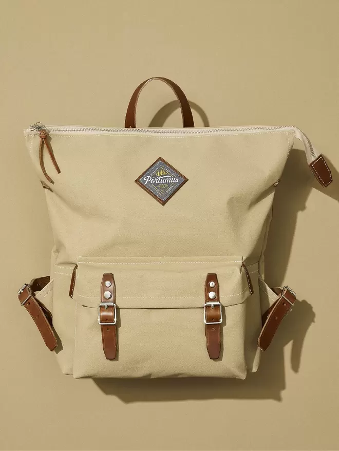 Taupe zip top Shortwood rucksack with brown leather straps shown on a natural background.
