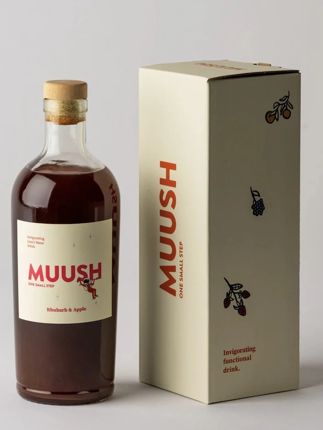 Rhubarb & Apple Elixir, a bottle of elixir sitting next to a packaged bottle on a plain surface. 