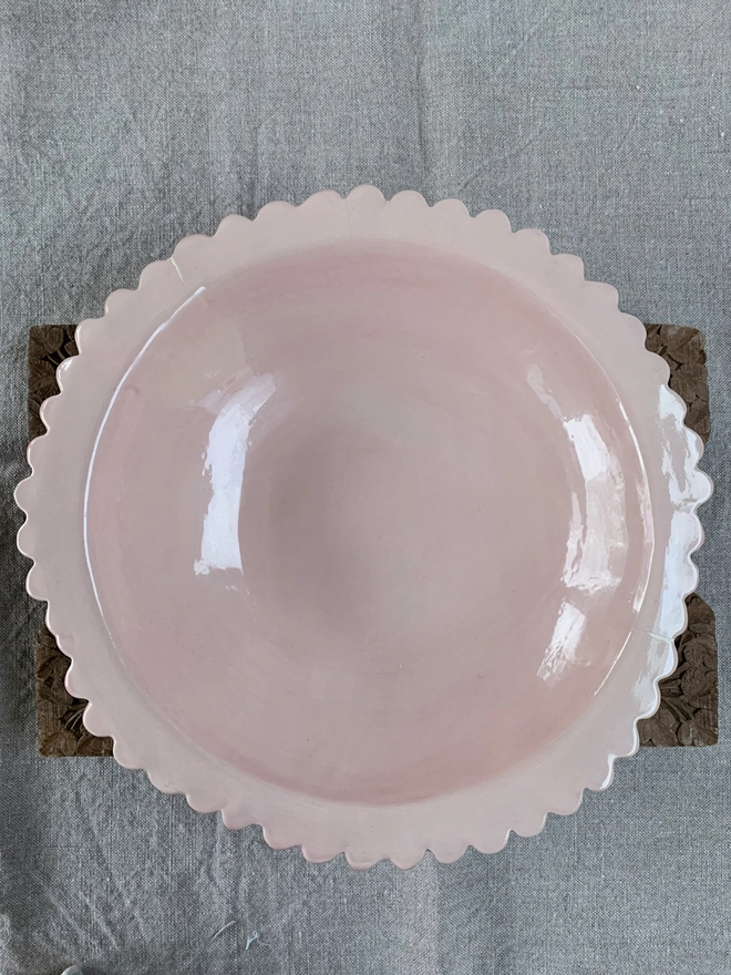 top down view of large pale pink serving bowl with scalloped edge