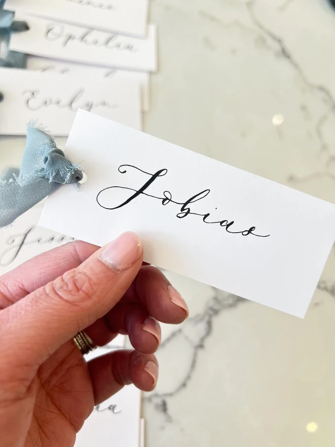 Personalised Calligraphy Wedding White Place Cards, white place cards with dusky blue chiffon ribbon. 