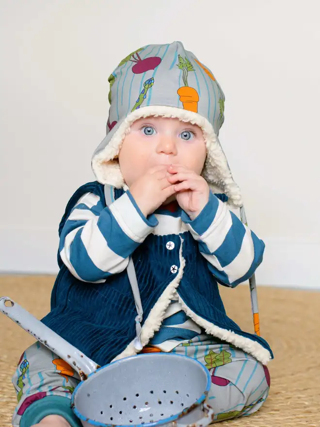 Petrol corduroy gilet on baby eating veg