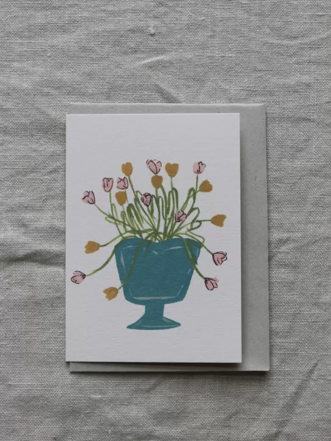 card with tulips arranged in a bright blue vase.