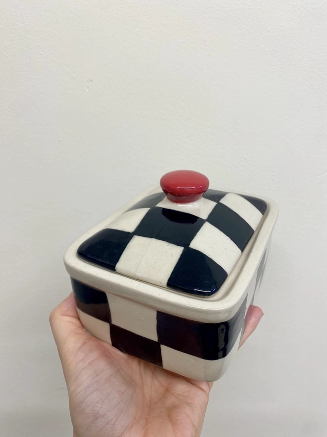  Checkered Black & Cream Handmade Ceramic Butter Dish, a black and white butter dish held against a white backdrop. 