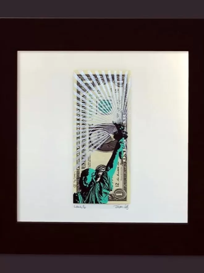 One Dollar Note with Statue of Liberty printed on top in green and black with white glitter rays in a black frame with a white mount