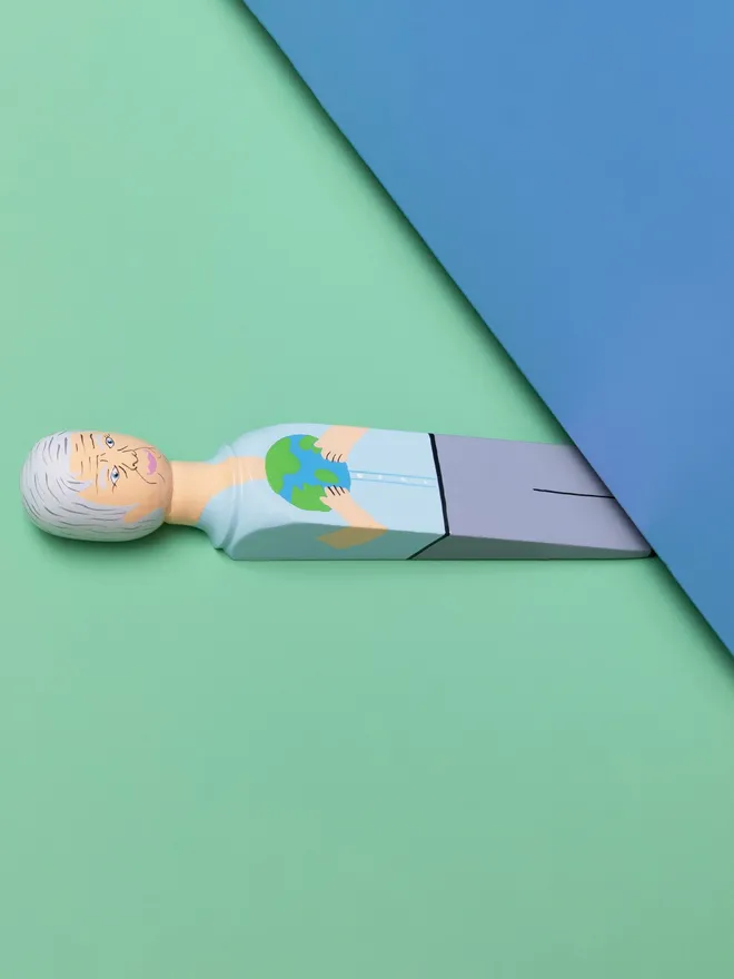 Wooden Door Stopper (Planet Dave), a colourful wooden door stop sitting under a door.