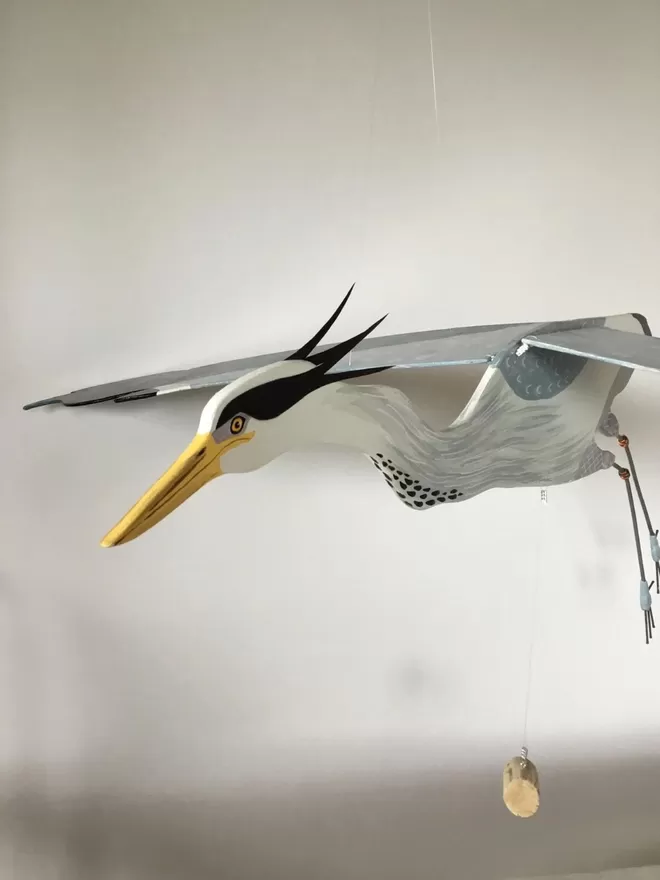 angled view of Heron hanging in front of white wall