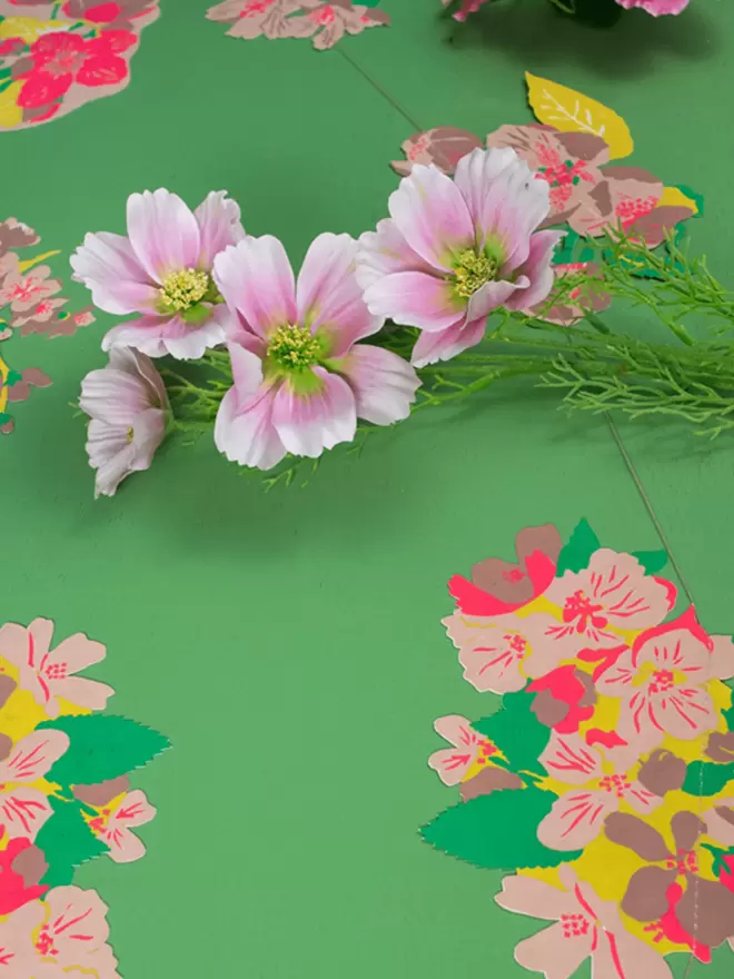 Blossom garland, pink flowers and green background
