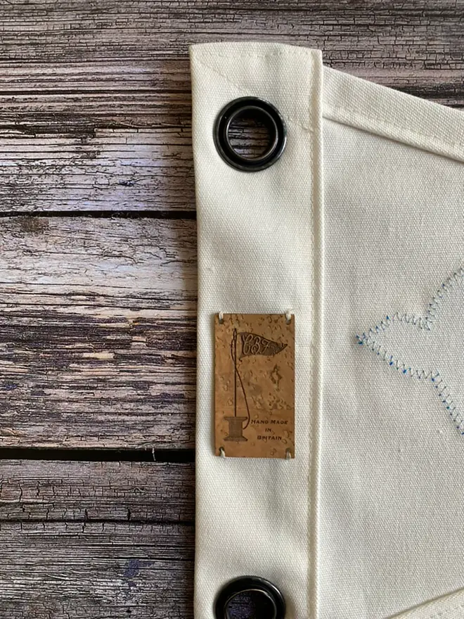 a close up of a section of a swallows flag on the reverse showing the eyelets and cork label