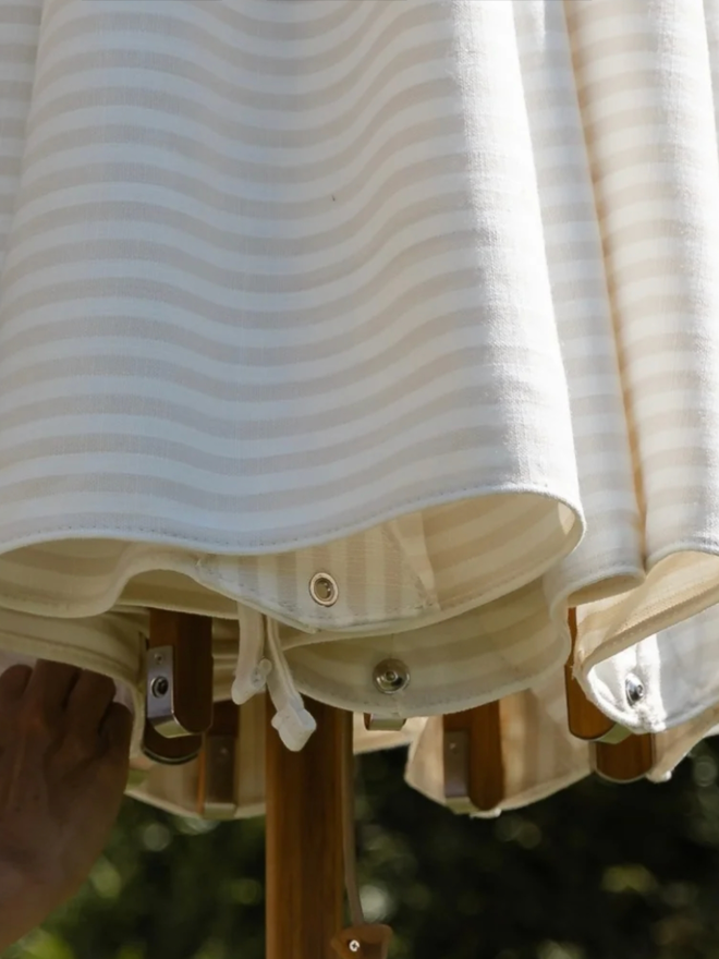 Beige & White Striped Parasol. A white, striped parasol.
