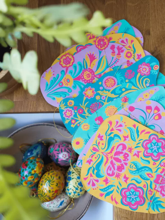 Garland shapes placed on wooden surface, with hand-painted wooden easter eggs in foreground