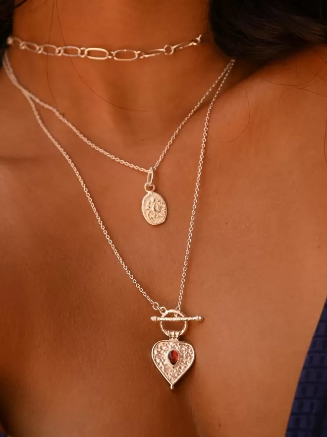 Model wearing silver layering necklaces with silver toggle heart pendant by Loft & Daughter