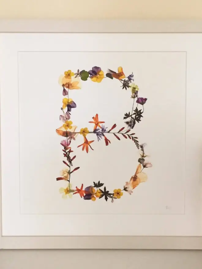 Pressed Wildflower Letter Print, a wildflower alphabet letter print sitting framed. 