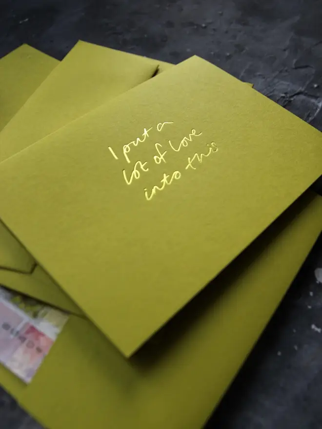 Hand foiled cash card or money wallet in a chartreuse green colour handfoiled in shiny yellow foil text which says ‘I put a lot of love into this’.