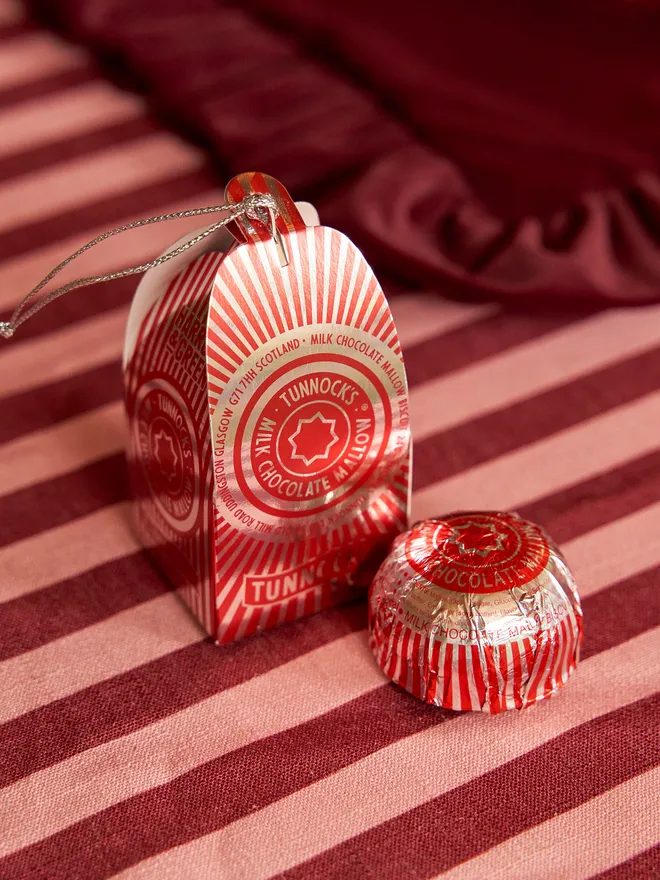 Tunnock's Tea Cake Christmas Bauble on a red striped tablecloth