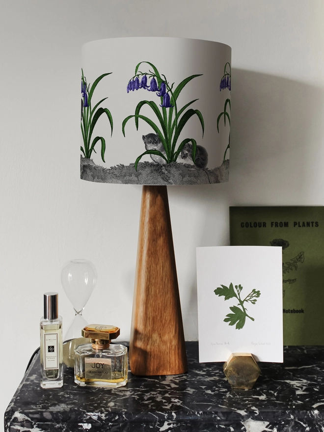 A whimsical lampshade featuring adorable mice hiding among bluebells, creating a charming woodland-inspired design.