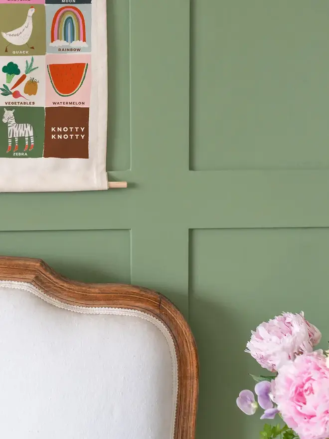 Colourful Rainbow Alphabet Fabric Banner, hanging on a green wall. 