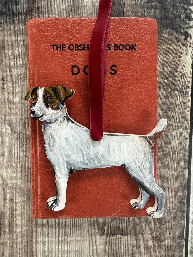 Smooth Haired Jack russell wooden Dog  Christmas Decoration With Red ribbon placed on  small book about dogs