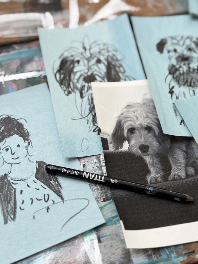 sketchy portrait of girl and dog on blue paper on drawing board