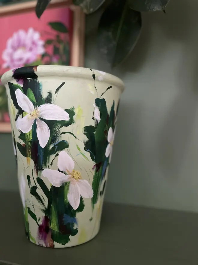 hand painted floral terracotta interior plant pot pale green background white clematis flowers