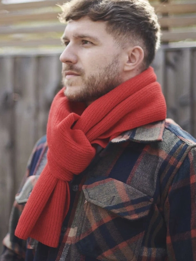 Lambswool Ribbed Scarf, a man wearing a colourful ribbed scarf outdoors. 