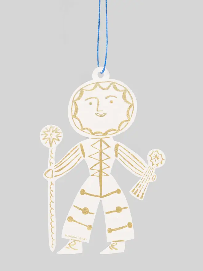 Decorative Sun Folk ornament in gold and white on a gray background