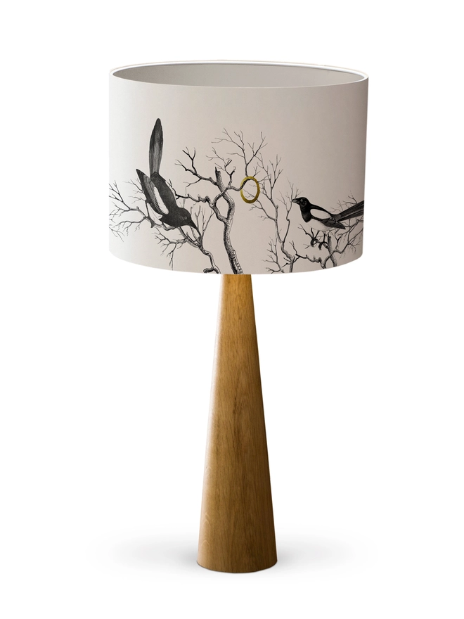 Handmade lampshade featuring cheeky magpies with gleaming gold details, inspired by traditional folklore and whimsical home decor.