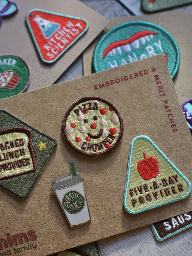 merit patches and pins with a food theme, contsinning pizza chomper, five-a-day provider, packed lunch provider