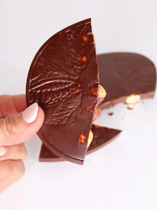 75% Vegan Chocolate With Hazelnuts Easter Egg broken up and being held