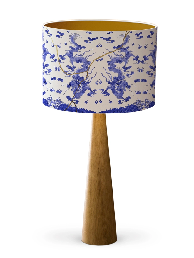 Drum Lampshade blue and white kintsugi inspired featuring Japanese dragons with a gold inner on a wooden base on a white background