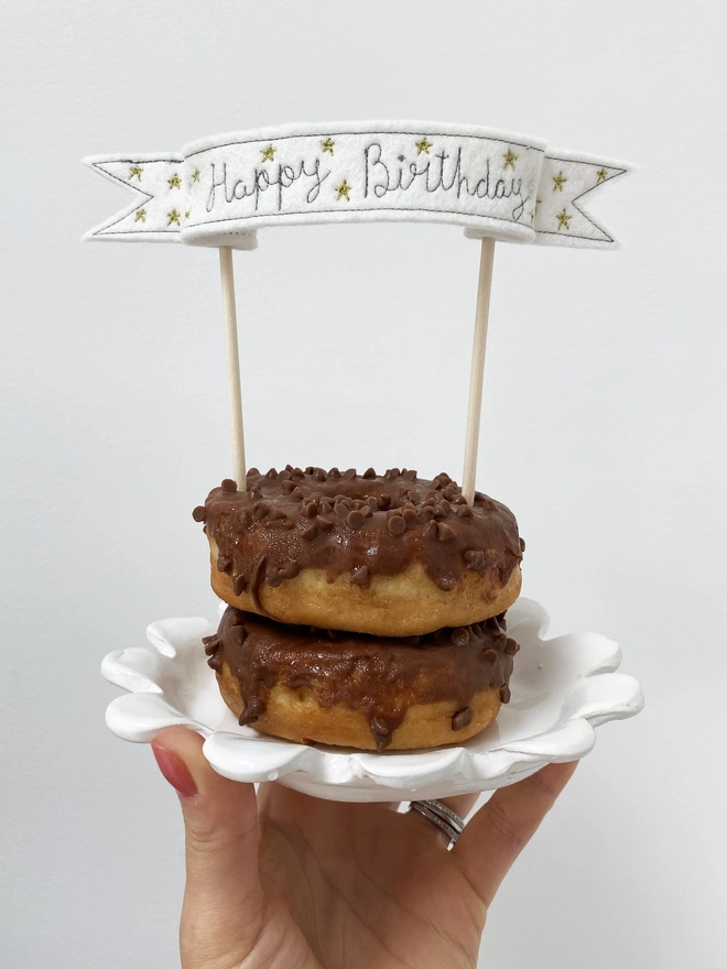 Star Banner Cake Topper with two chocolate doughnuts on plate 