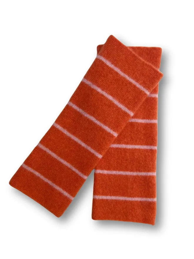 Colourful orange wristwarmers shown on a white background.