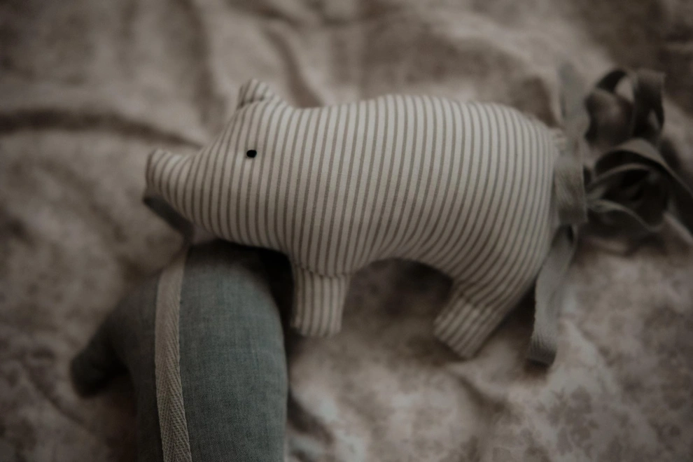Pig Garland Decoration, a grey and white pig garland decoration in a child's bedroom. It is accompanied by other bedroom accessories. 