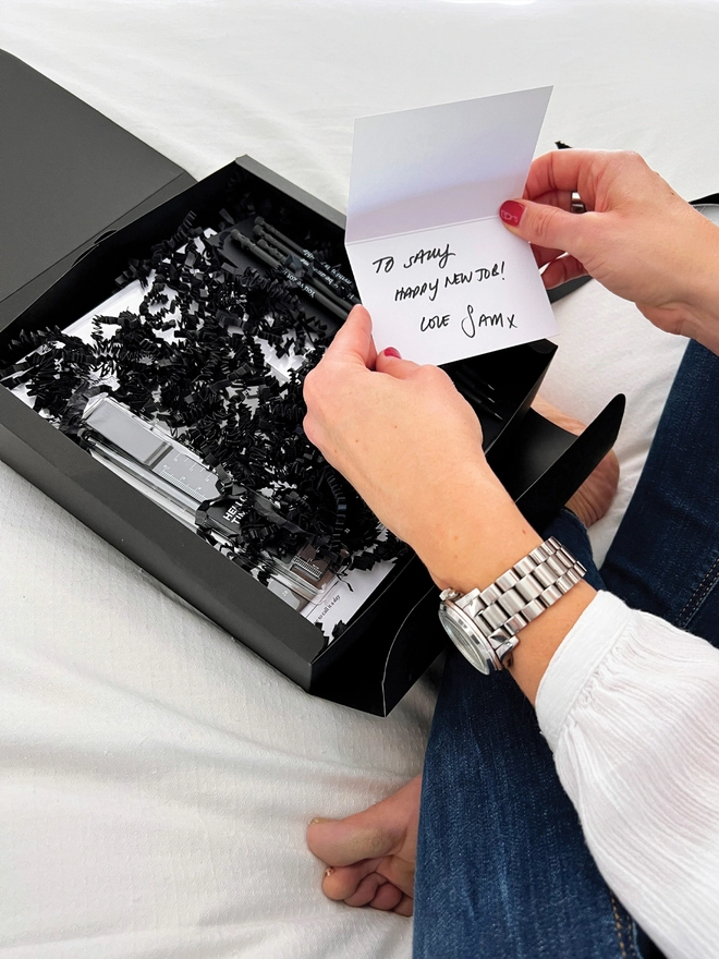 Lady holding open a notecard above an open Stationery Lovers Selection Gift Box